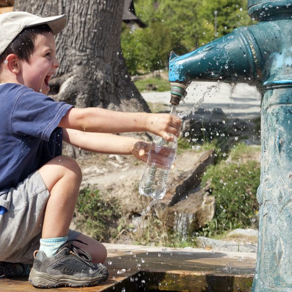 Happy Child Filling Water Bottle_Social Impact Management